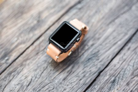 Téléchargez les photos : Smartwatch avec bracelet de montre en cuir véritable sur table en bois - en image libre de droit