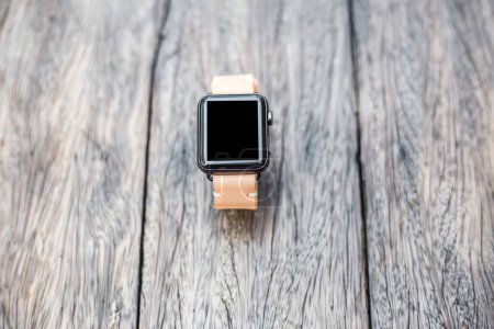 Foto de Reloj inteligente con correa de reloj de cuero genuino en mesa de madera - Imagen libre de derechos