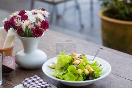 Téléchargez les photos : Salade maison aliments sains avec vase à fleurs sur table en bois - en image libre de droit
