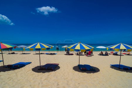 Téléchargez les photos : Chaises longues et parasols à la mer plage contre ciel bleu, vacances d'été - en image libre de droit