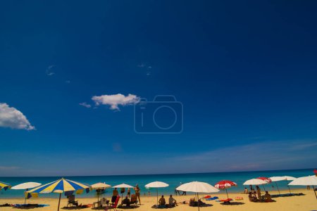 Téléchargez les photos : Chaises longues et parasols à la mer plage contre ciel bleu, vacances d'été - en image libre de droit