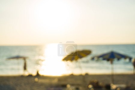 Foto de La gente borrosa abstracta que se relajaba en la playa del mar al atardecer. Fondo de vacaciones de verano - Imagen libre de derechos