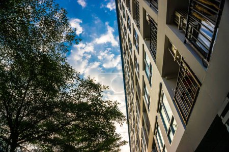 Téléchargez les photos : Condominium moderne avec de nombreuses fenêtres contre le ciel bleu, copropriété résidentielle de la ville - en image libre de droit