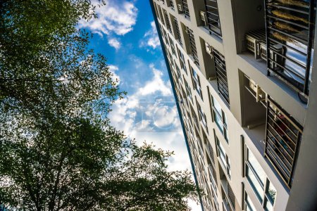 Téléchargez les photos : Condominium moderne avec de nombreuses fenêtres contre le ciel bleu, copropriété résidentielle de la ville - en image libre de droit