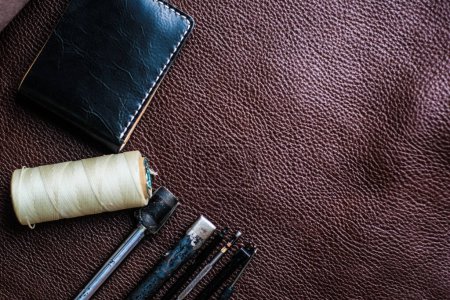 Photo for Genuine leather bifold wallet and tools for working with leather, craftmanship objects - Royalty Free Image