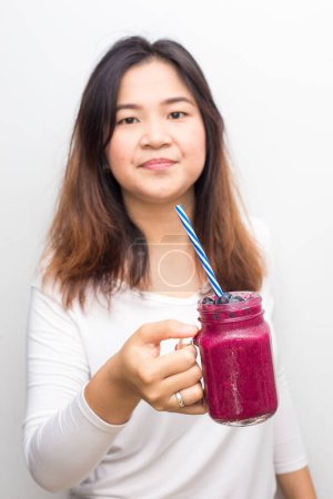 Téléchargez les photos : Femme en bonne santé boire smoothie myrtille sur fond blanc - en image libre de droit