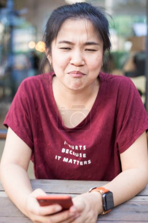 Foto de Mujer asiática usando smartphone en cafetería - Imagen libre de derechos