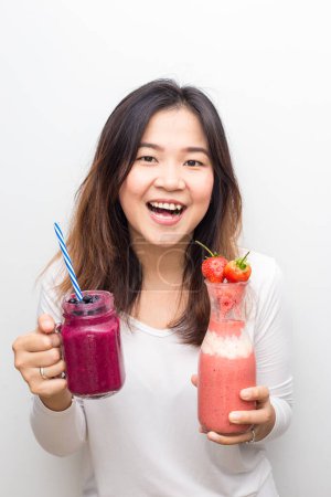 Téléchargez les photos : Smart femme en bonne santé buvant smoothies myrtille mélanger les fruits sur fond blanc - en image libre de droit