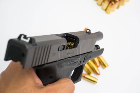 Foto de Pistola micro sompact automática de 9 mm con bala sobre fondo blanco - Imagen libre de derechos