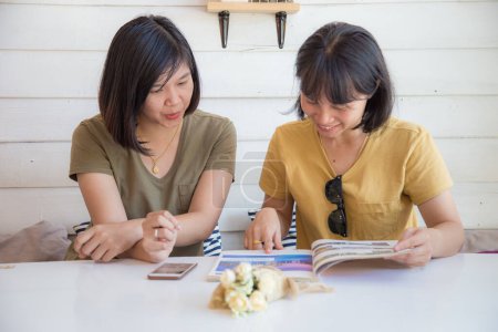Téléchargez les photos : Heureux asiatique lesbienne couple boire café assis dans café couple de l'amour - en image libre de droit
