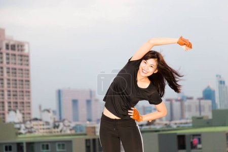 Photo for Asian sporty and fit women stand over city background stretching for fitness - Royalty Free Image