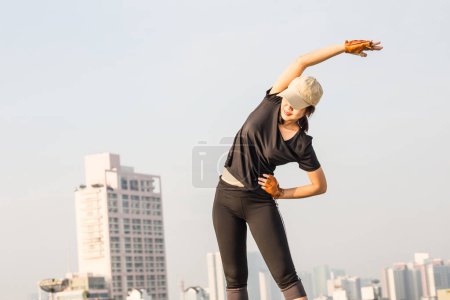 Téléchargez les photos : Souriant sport asiatique femme étirement pour remise en forme sur le dessus de la construction, les femmes faisant de l'exercice - en image libre de droit