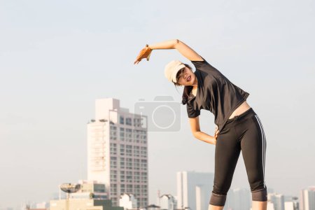 Téléchargez les photos : Souriant sport asiatique femme étirement pour remise en forme sur le dessus de la construction, les femmes faisant de l'exercice - en image libre de droit
