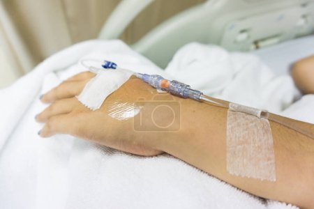 Téléchargez les photos : Maladie des mains avec intraveineuse au patient sur couverture blanche - en image libre de droit