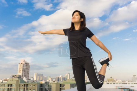 Photo for Fitness runner body closeup doing warm-up routine on roof top building before running, cardio workout. - Royalty Free Image