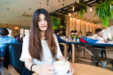 Foto de Café biblioteca retrato de asiático universidad mujer bebiendo latte arte café en un café - Imagen libre de derechos