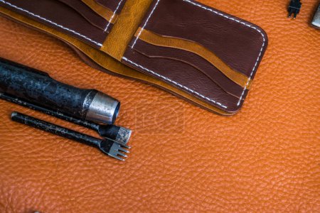Foto de Artesanía de cuero para billetera que trabaja con herramientas en el escritorio del artesano de cuero
 . - Imagen libre de derechos