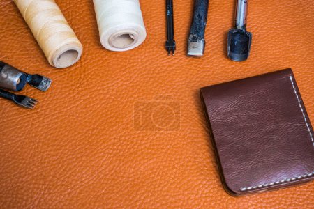 Foto de Artesanía de cuero para billetera que trabaja con herramientas en el escritorio del artesano de cuero
 . - Imagen libre de derechos