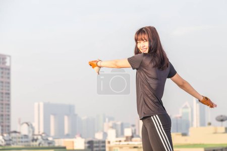 Téléchargez les photos : Asiatique femelle dans les vêtements de sport font corps étirement avant l'entraînement sur fond de construction
. - en image libre de droit