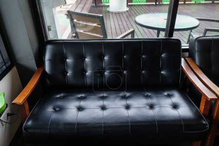 Foto de Sofá de cuero de lujo brazo de madera en café vintage, Muebles de interior - Imagen libre de derechos
