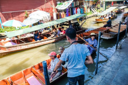 Photo for BANGKOK  MARCH 25: Boat service with tourist people at Damnoen Saduak floating market on March 25, 2017 in Bangkok. Traditional popular place of buying and selling still practiced in Damnoen Saduak canals of Thailand - Royalty Free Image