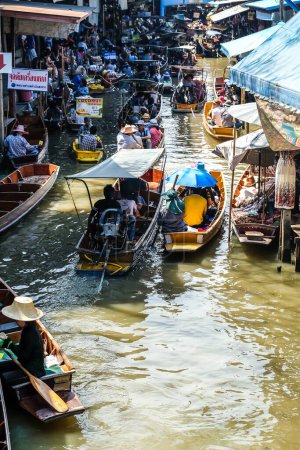 Foto de BANGKOK 25 DE MARZO: Servicio de barco con turistas en el mercado flotante Damnoen Saduak el 25 de marzo de 2017 en Bangkok. Lugar popular tradicional de compra y venta todavía se practica en los canales de Damnoen Saduak de Tailandia - Imagen libre de derechos