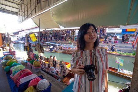 Photo for Beautiful tourost woman travel in floating market take photo at Amphawa is a very popular floating market in Thailand - Royalty Free Image
