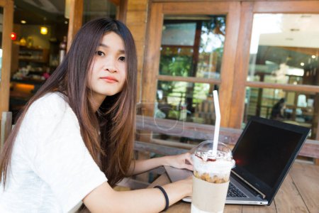 Foto de Hermosa mujer estudiante hipster usando portátil y beber café en la cafetería - Imagen libre de derechos