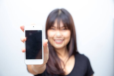 Téléchargez les photos : Belle femme asiatique montrer écran vide de smartphone sur fond blanc maquette concept multimédia - en image libre de droit