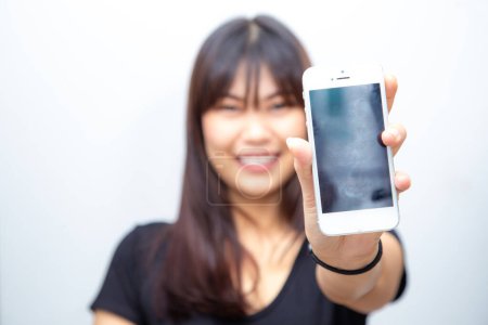 Téléchargez les photos : Belle femme asiatique montrer écran vide de smartphone sur fond blanc maquette concept multimédia - en image libre de droit