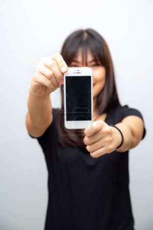 Foto de Hermosa mujer asiática muestran pantalla vacía de teléfono inteligente sobre fondo blanco simulacro de concepto de medios - Imagen libre de derechos