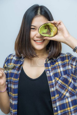 Photo for Happy young beautiful women holding avocado for eat on white background - Royalty Free Image