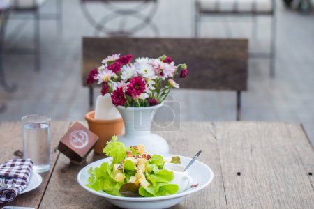Foto de Ensalada casera comida saludable con florero en mesa de madera - Imagen libre de derechos
