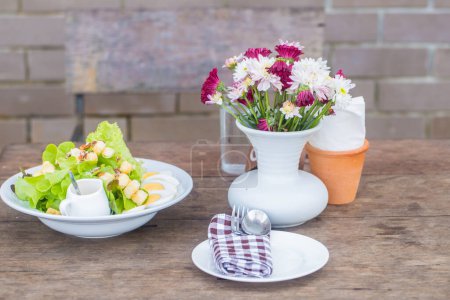 Photo for Homemade salad healthy food with flower vase on wood table - Royalty Free Image