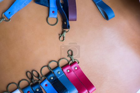 Photo for Genuine leather color keychain with metal head on leather background - Royalty Free Image