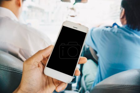 Téléchargez les photos : Homme d'affaires main utiliser smartphone dans l'écran vierge de voiture - en image libre de droit