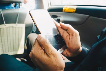 Foto de Hombre de negocios mano uso de teléfono inteligente en la pantalla en blanco del coche - Imagen libre de derechos