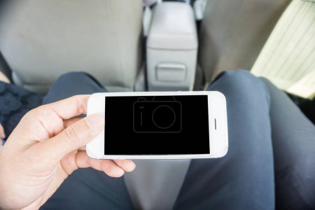 Téléchargez les photos : Homme d'affaires main utiliser smartphone dans l'écran vierge de voiture - en image libre de droit