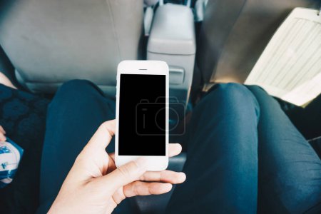 Foto de Hombre de negocios mano uso de teléfono inteligente en la pantalla en blanco del coche - Imagen libre de derechos