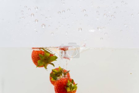 Photo for Fresh strawberry splash in water on white background - Royalty Free Image