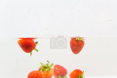 Photo for Fresh strawberry splash in water on white background - Royalty Free Image