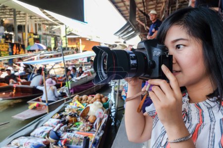 Téléchargez les photos : Les femmes prennent des photos de voyage dans le marché flottant, Thaïlande - en image libre de droit