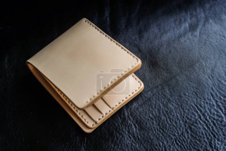 Photo for Vegetable tanned leather wallet on black leather background, Craftsmanship object - Royalty Free Image