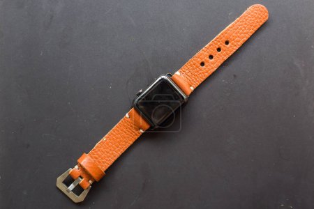 Foto de Correa de reloj de cuero genuino con reloj inteligente sobre fondo negro - Imagen libre de derechos