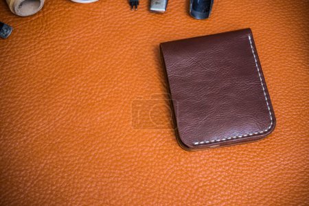 Photo for Genuine cowhide leather wallet handmade with tool top view craftsmanship working - Royalty Free Image
