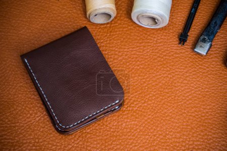 Photo for Genuine cowhide leather wallet handmade with tool top view craftsmanship working - Royalty Free Image