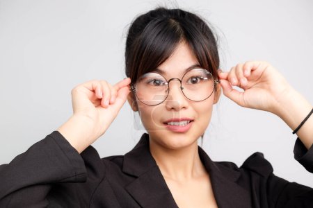 Foto de Hermosa atractivo negocio asiático mujeres desgaste gafas sonriendo en blanco fondo negro traje negocios mujeres - Imagen libre de derechos