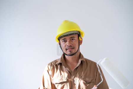 Téléchargez les photos : Peintre d'intérieur homme travaillant sur blanc nouvelle maison intérieur salle rénover design - en image libre de droit
