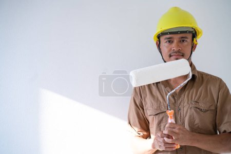 Téléchargez les photos : Peintre d'intérieur homme travaillant sur blanc nouvelle maison intérieur salle rénover design - en image libre de droit
