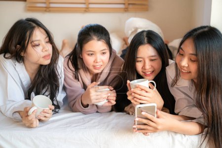 Foto de Hermosa asiático mujer amigo meetin en blanco cama uso smartphone juntos feliz amistad tiempo - Imagen libre de derechos